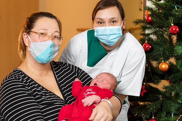 Weihnachtsbaby Marten im Arm seiner Mama Carola Kopistecki. Auf der Wöchnerinnenstation im Helios Klinikum Berlin-Buch steht ihnen Sabrina Ludwig, Gesundheits- und Krankenpflegerin, zur Seite. (Foto: Helios/Thomas Oberländer)