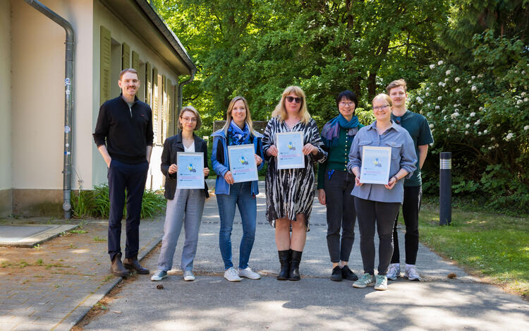Christian Panetzky, Koordinator für Nachhaltigkeit (links), mit Vertreter*innen aus den Arbeitsgruppen. In ihren Händen halten sie mit den LEAF-Zertifikaten die Ergebnisse ihres Engagements. (© Felix Petermann, Max Delbrück Center)